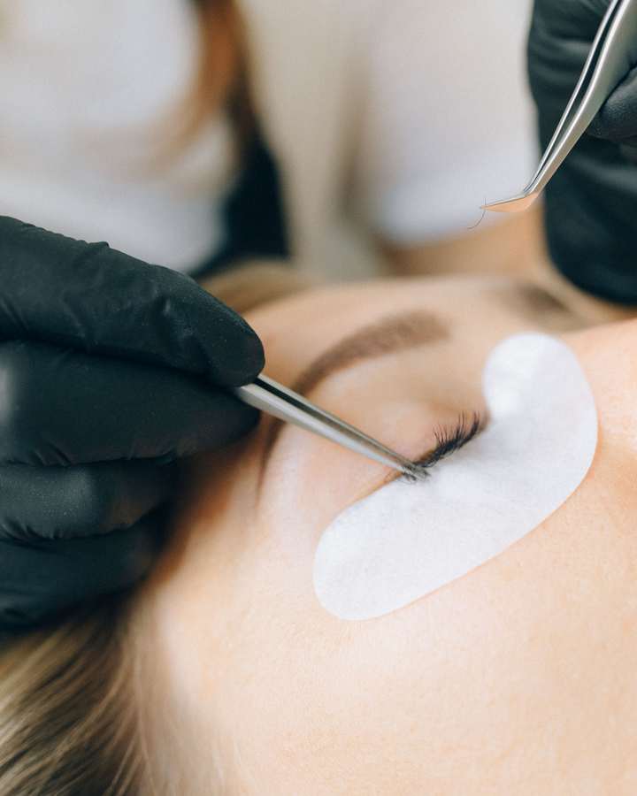 Präzise Arbeit mit der Pinzette bei einer Wimpernverlängerung